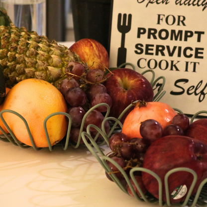 Naomi Green food-safe fruit basket made of iron, featuring a textured powder-coated finish, perfect for storing and displaying fresh fruits in a stylish and durable way