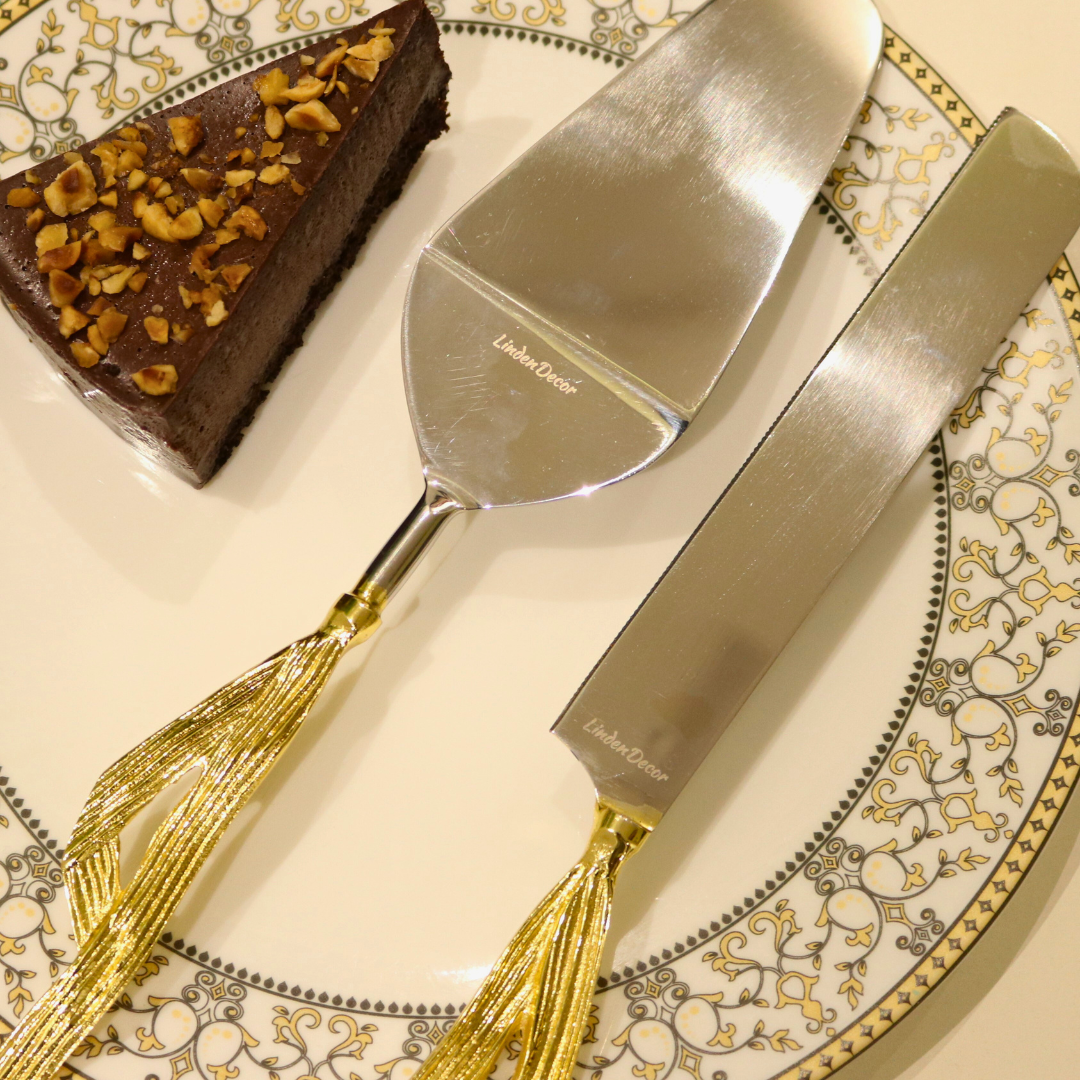 Golden Maize Leaf Cake Server Set with stainless steel blades and maize leaf-inspired handles, elegantly placed on a decorative plate with a slice of chocolate cake